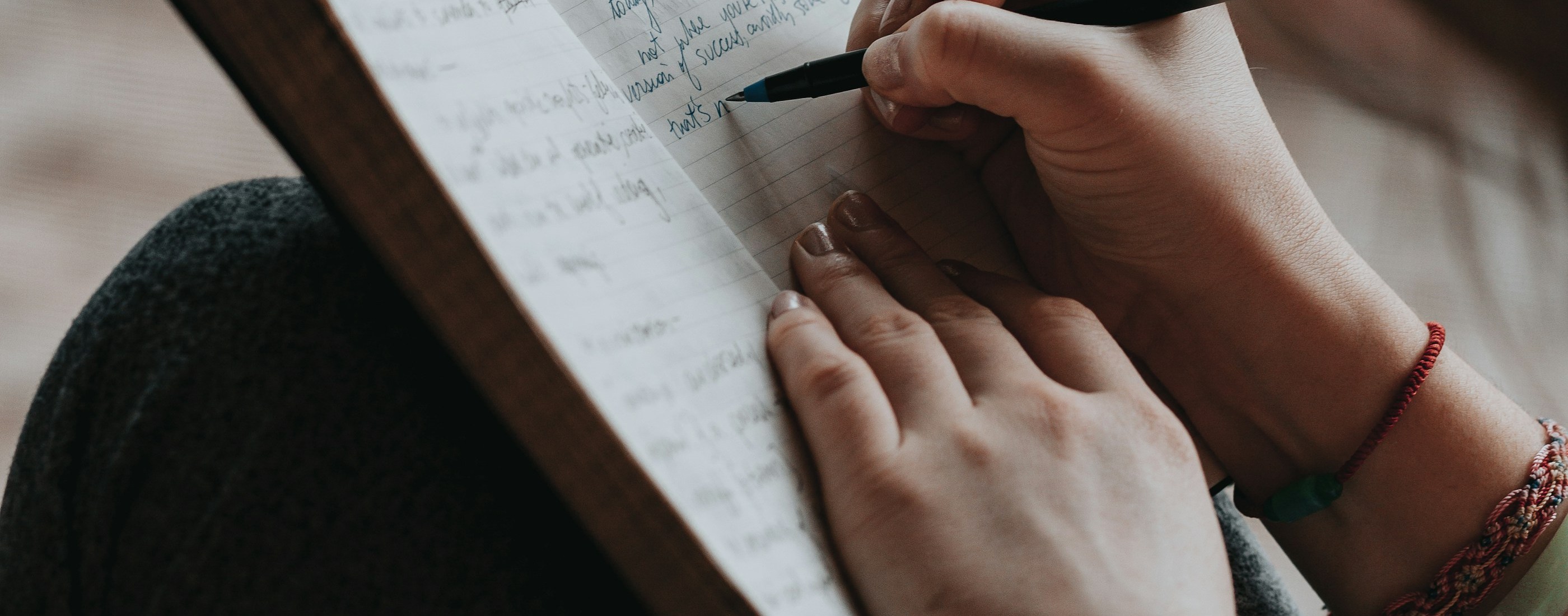 A writer drafting copy in a notebook