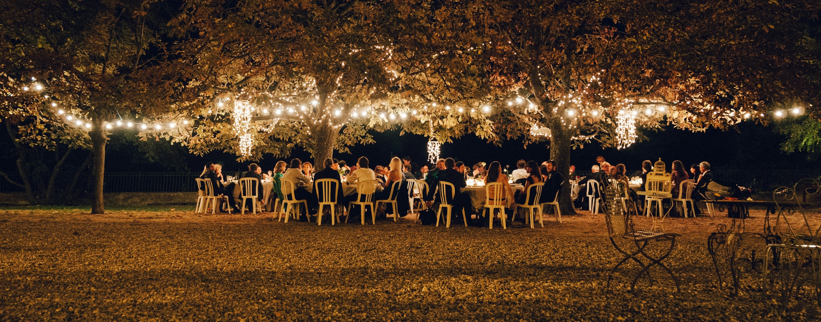 A wedding reception under string lights at night