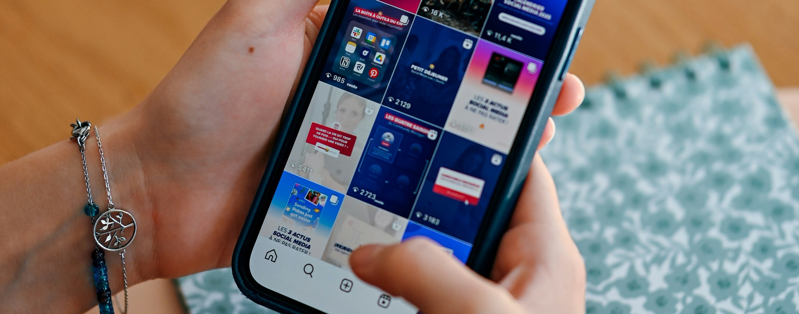 Hands holding a phone scrolling a social media feed
