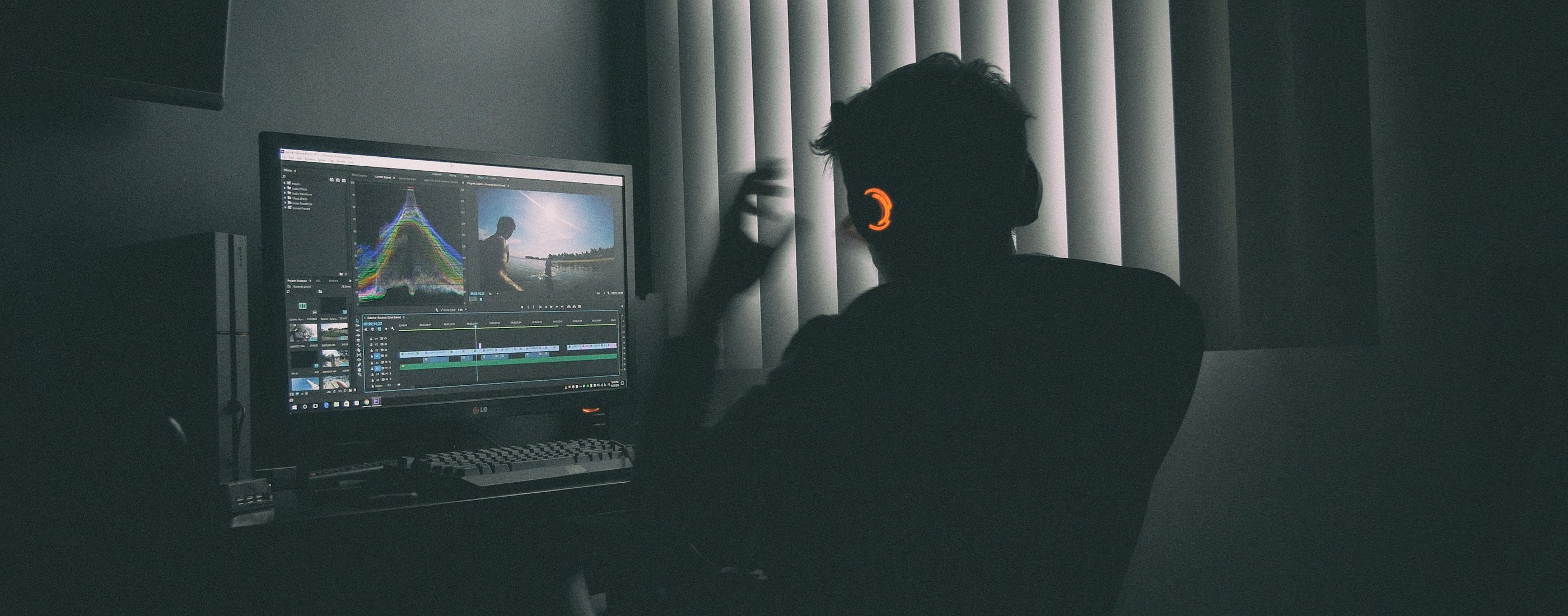 A video editor working at a screen in a dark studio